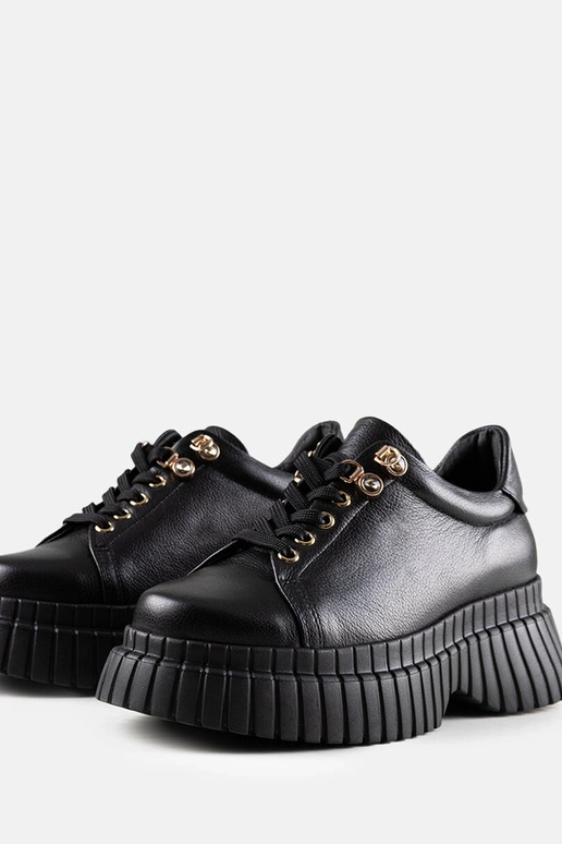 Melni ādas sporta apavi uz platformas...