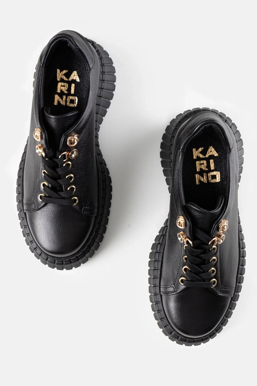 Melni ādas sporta apavi uz platformas...