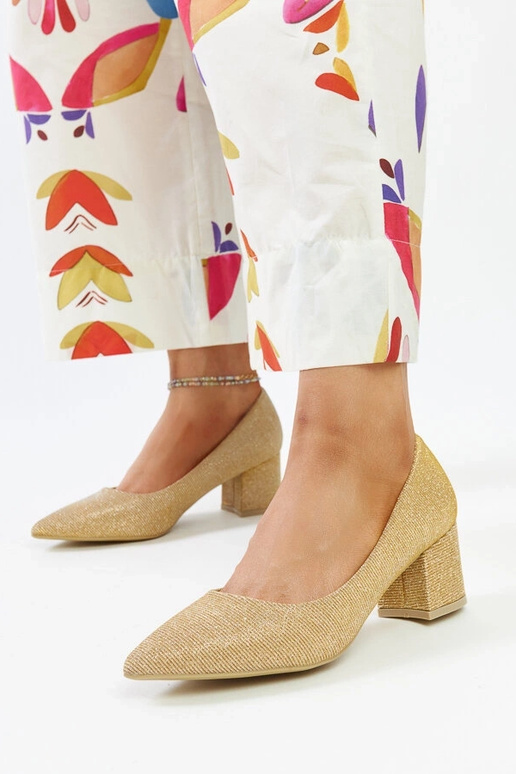 Zeltaini spīdošas papēžu kurpes uz... Zeltaini spīdošas papēžu kurpes uz...