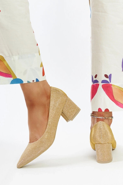 Zeltaini spīdošas papēžu kurpes uz... Zeltaini spīdošas papēžu kurpes uz...