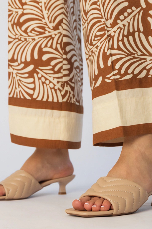 Gaiši smilškrāsas čības uz zema...