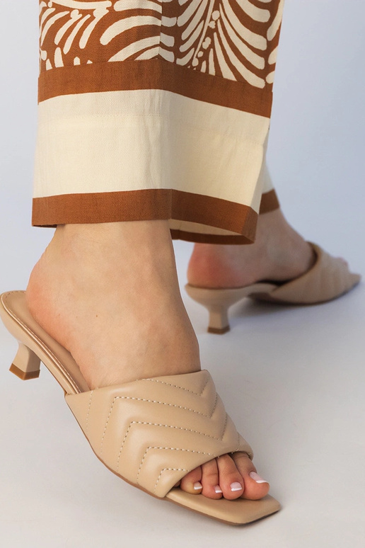 Gaiši smilškrāsas čības uz zema...