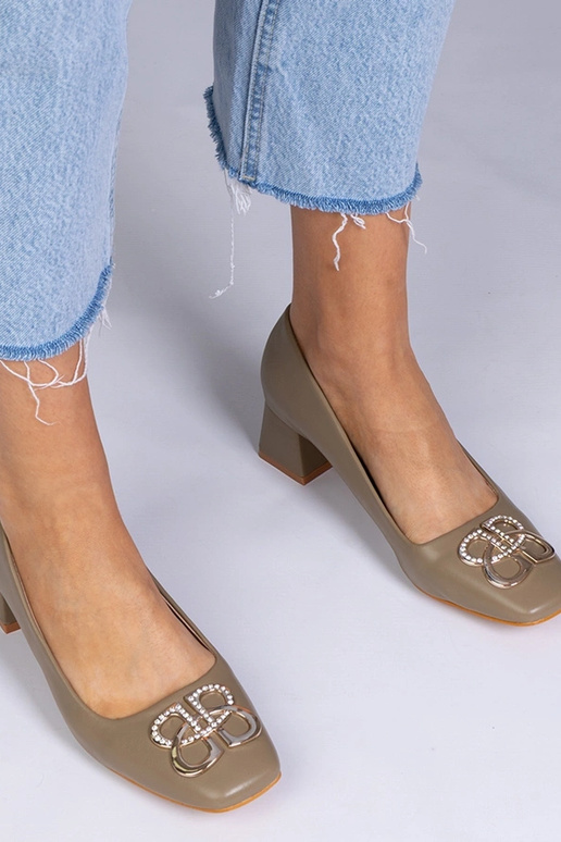 Zaļas augstpapēžu kurpes uz zema...