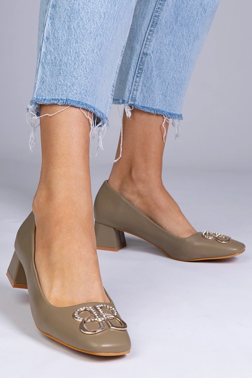 Zaļas augstpapēžu kurpes uz zema...