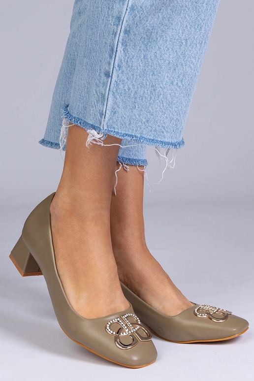 Zaļas augstpapēžu kurpes uz zema...