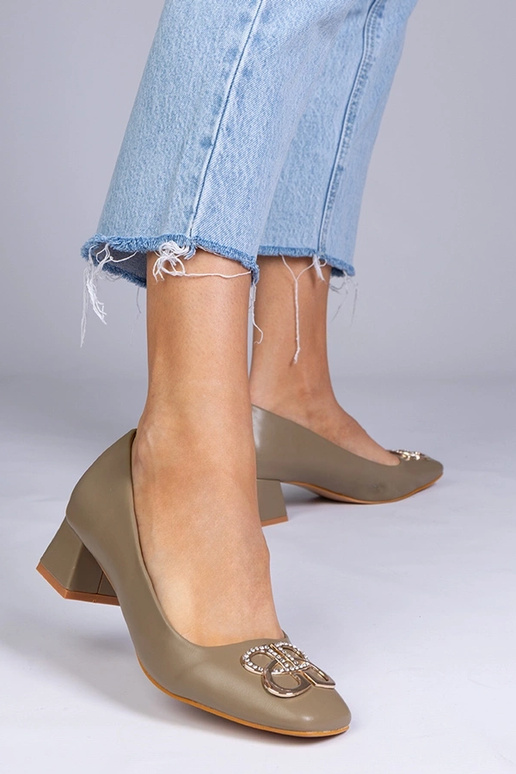 Zaļas augstpapēžu kurpes uz zema...