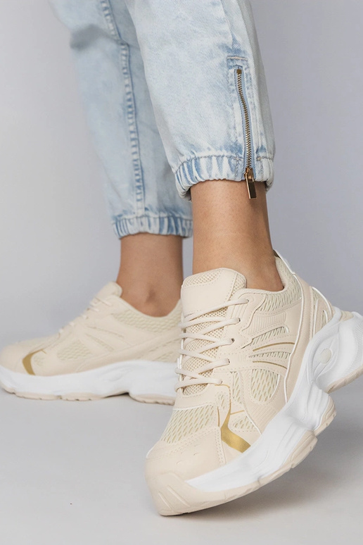 Smilšu krāsas sporta apavi uz masīvās...