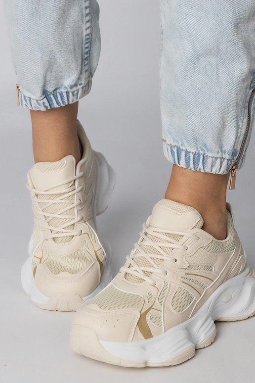 Smilšu krāsas sporta apavi uz masīvās...