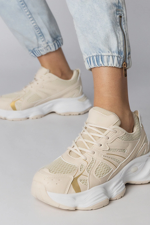 Smilšu krāsas sporta apavi uz masīvās...