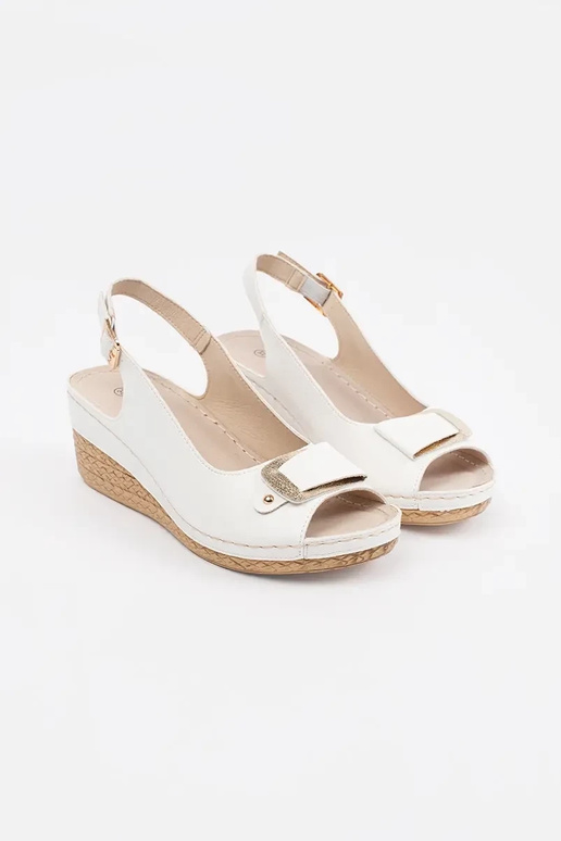 Baltas krāsas sandalī uz zema pleca...