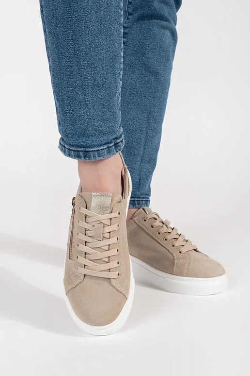 Smilšu krāsas sporta apavi uz bieza...