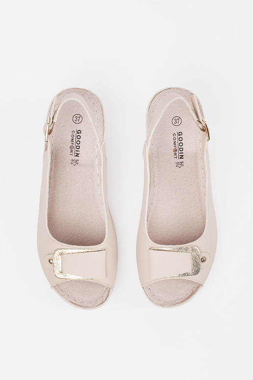 ivoru krāsas sandales uz zema pleca