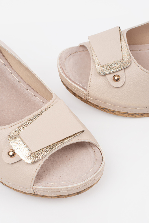 ivoru krāsas sandales uz zema pleca