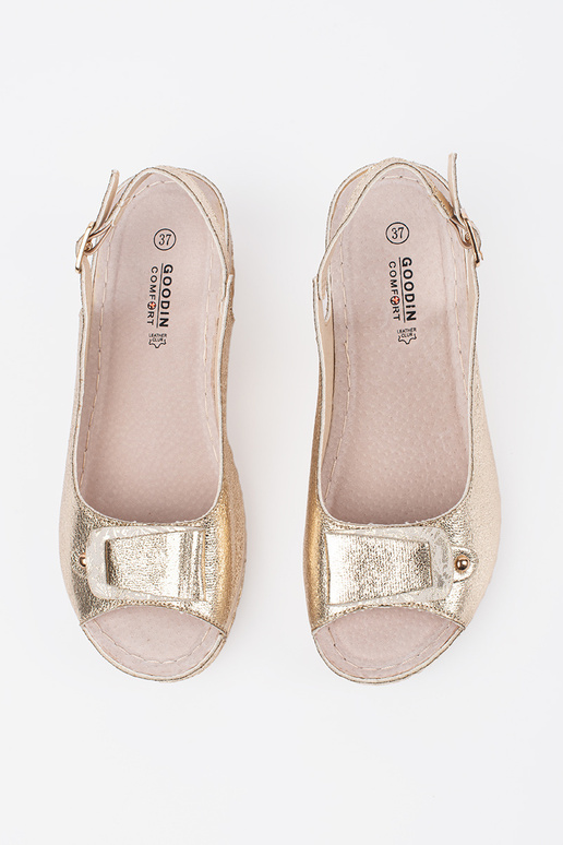 Zelta krāsas sandales uz zema pleisa