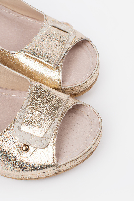 Zelta krāsas sandales uz zema pleisa