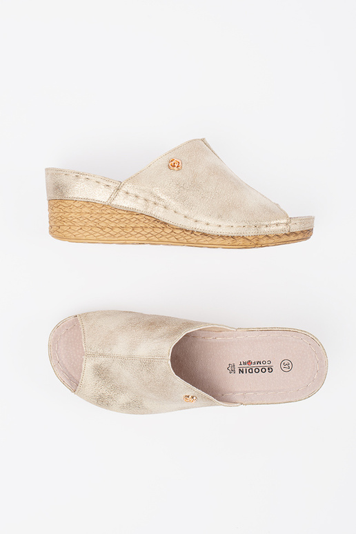 Zelta krāsas šlepes uz pleisa sievietēm