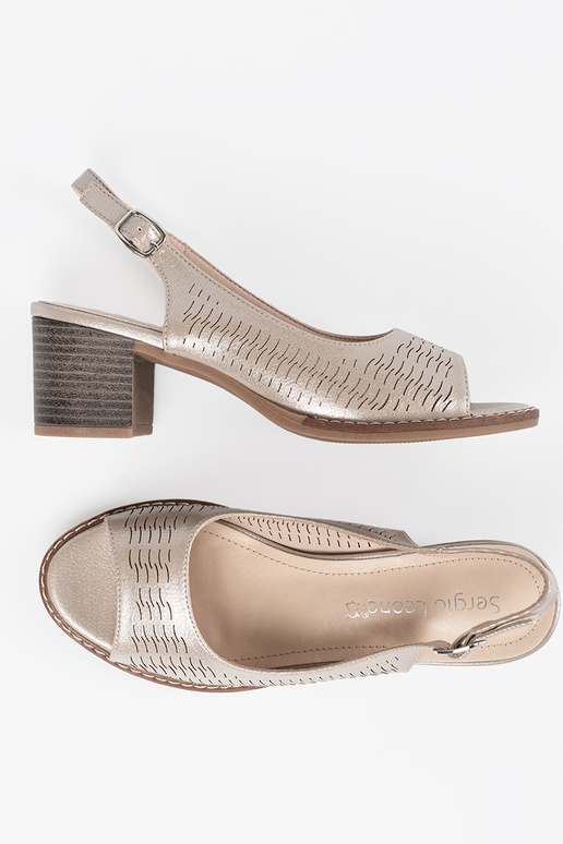 Zelta krāsas sieviešu apavi uz zema...