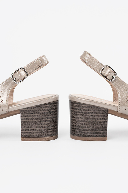 Zelta krāsas sieviešu apavi uz zema...