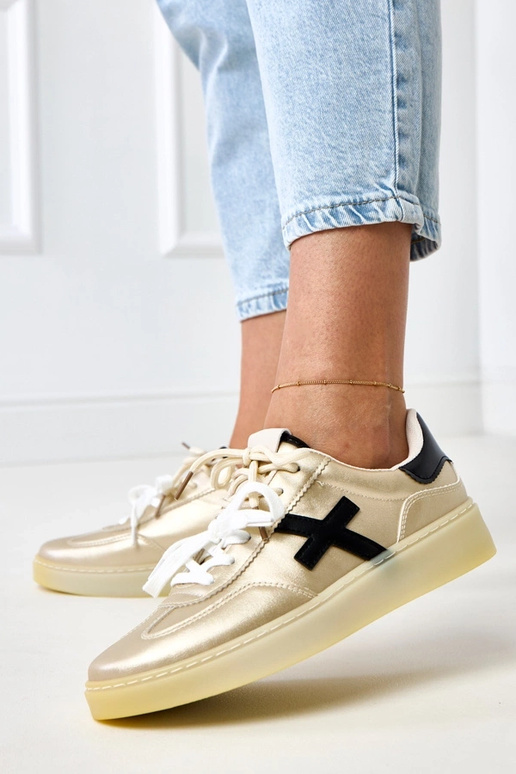 Zelta sporta apavi uz platformas ar... Zelta sporta apavi uz platformas ar...