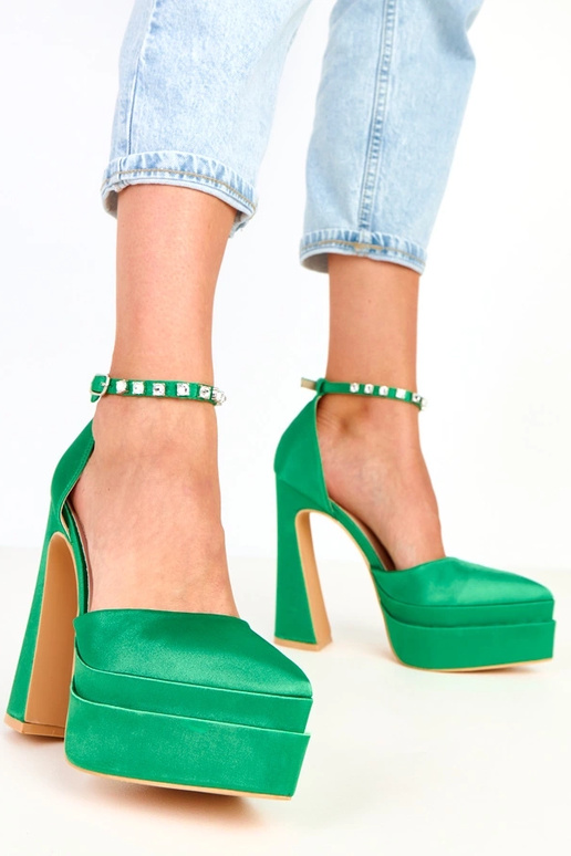 Zaļi augstpapēžu zābaki uz platformas...