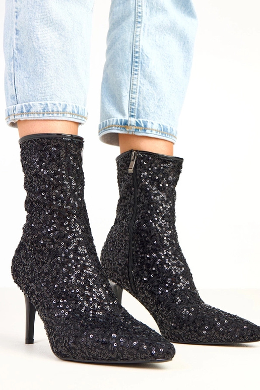 Melni botīnes ar mirdzošu apdari uz...
