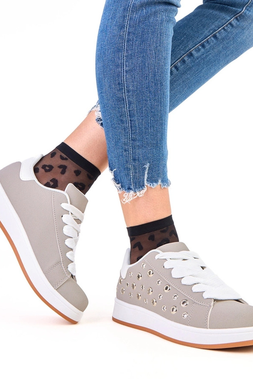 Pelēki sporta apavi uz platformas ar...