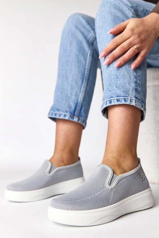 Pelēki auduma sporta apavi platformā...