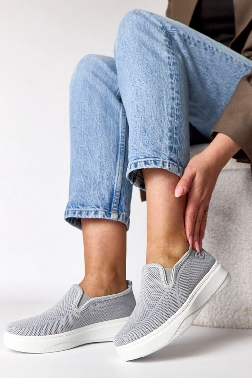 Pelēki auduma sporta apavi platformā...