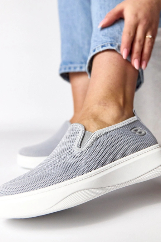 Pelēki auduma sporta apavi platformā...