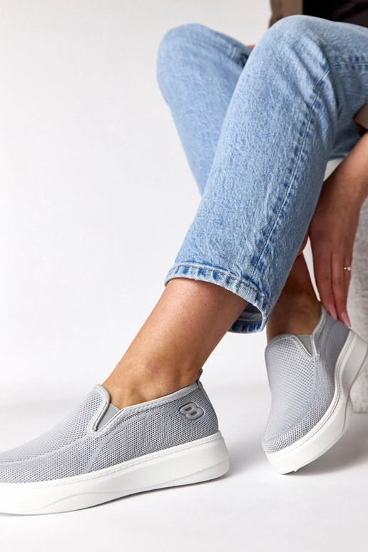 Pelēki auduma sporta apavi platformā...