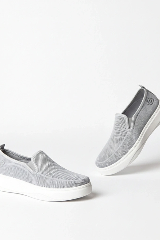 Pelēki auduma sporta apavi platformā...